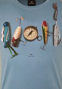Camiseta de algodón de color azul claro con un gráfico de herramientas de pesca, una brújula y un cuchillo de bolsillo, con un logo debajo.