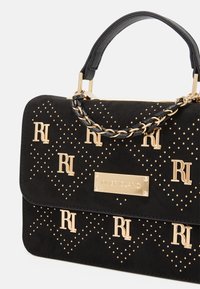 Czarna torebka z sztucznego zamszu z ozdobami z złotych ćwieków i logo. Posiada łańcuszkowy pasek oraz usztywniane zamknięcie na klapę.