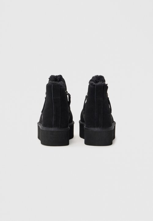 Crne antilop čizme do gležnja s visokim, teksturiranim platformom, umjetnim krznom na ovratniku i detaljem sa zatvaračem sa strane.