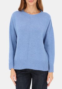 Jasnoniebieski dziany sweter z okrągłym dekoltem, ściągaczami na rękawach i dole; posiada środkowy szew oraz luźny krój.