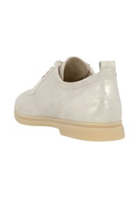 Baskets en suède beige clair avec une texture lisse, bout rond et semelle en caoutchouc basse. Comprend des lacets et un petit tirant à l'arrière.