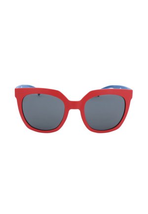 Occhiali da sole con montatura rossa, lenti grigio scuro e design leggermente a forma di occhio di gatto su sfondo bianco.