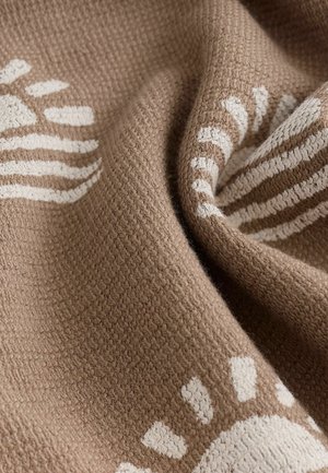 Țesătură maro texturată cu modele geometrice albe, având un design țesut. Suprafața pare moale și ușor pufoasă.