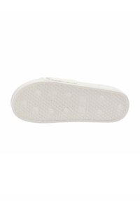 Suola di sneaker in gomma bianca con una superficie testurizzata, caratterizzata da indentazioni circolari e un design a griglia per una migliore aderenza.