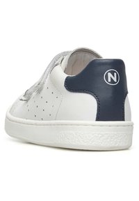 Sneaker bianca in pelle con tomaia perforata, dettagli in tessuto grigio e pannello sul tallone blu navy con logo circolare bianco. Suola piatta in gomma bianca.
