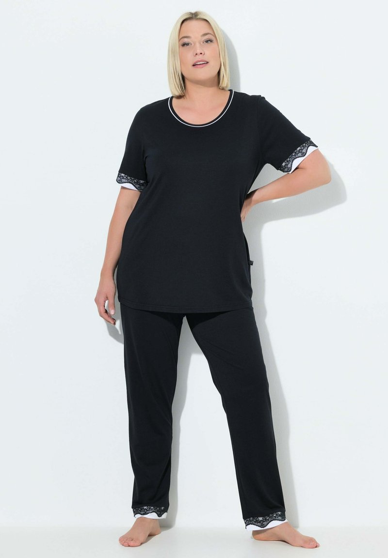Svart pyjamas-set med en topp med kort ärm och rund halsringning samt spetsdetaljer på ärmar och byxans nederkant; mjukt, slätt tyg.