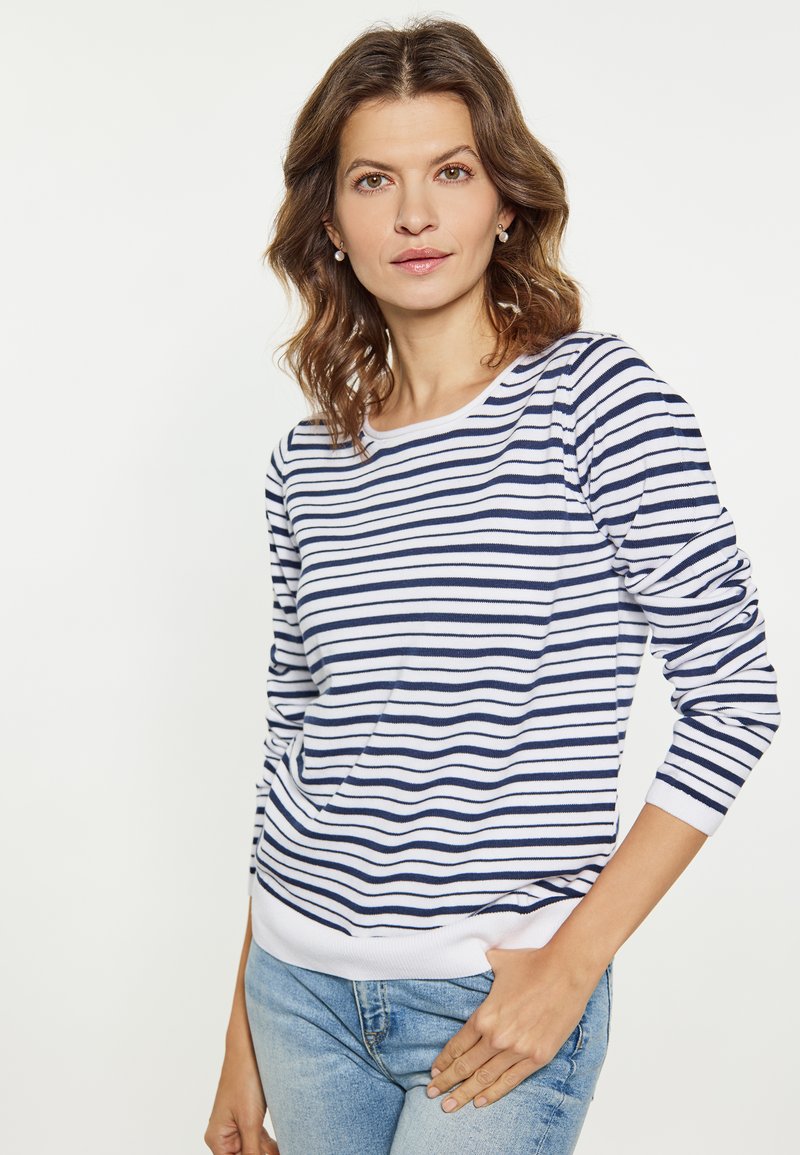 Tricou lung cu dungi albastre și albe, cu guler rotund și manșete strâmte, asortat cu blugi deschiși. Material moale cu o croială lejeră.