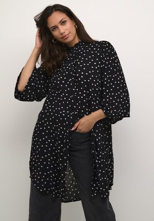 Zwarte blouse met stippen, met een knoopsluiting aan de voorkant, ruches bij de halslijn en driekwartmouwen, gemaakt van lichte stof.
