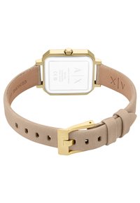 Šviesiai ruda odinė apyrankė su kvadratiniu auksinės spalvos korpusu ir baltu ciferblatu. Apyrankė turi smeigtuką ir išgraviruotą logotipą vidinėje pusėje.