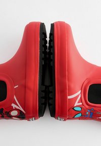 Rote Gummischuhe mit schwarzen strukturierten Sohlen, versehen mit Spider-Man-Grafiken, glatter Oberfläche und einem schlüpfbaren Design mit elastischen Seiten.