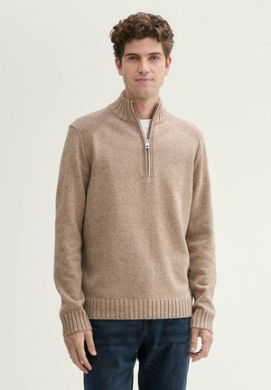Beige trui met ritssluiting en geribde manchetten en onderrand. Zachte textuur en aangesloten ontwerp. Combineren met donkere jeans zorgt voor contrast in de outfit.