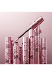 Tubi di mascara rosa impilati, alcuni in posizione verticale, con un applicatore nero che sporge. Il testo recita "High Sky" e "Maybelline" in carattere nero a contrasto.