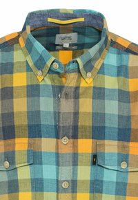 Chemise à col boutonné avec un motif à carreaux jaune, bleu, vert et gris et deux poches poitrine avant avec des boutons.