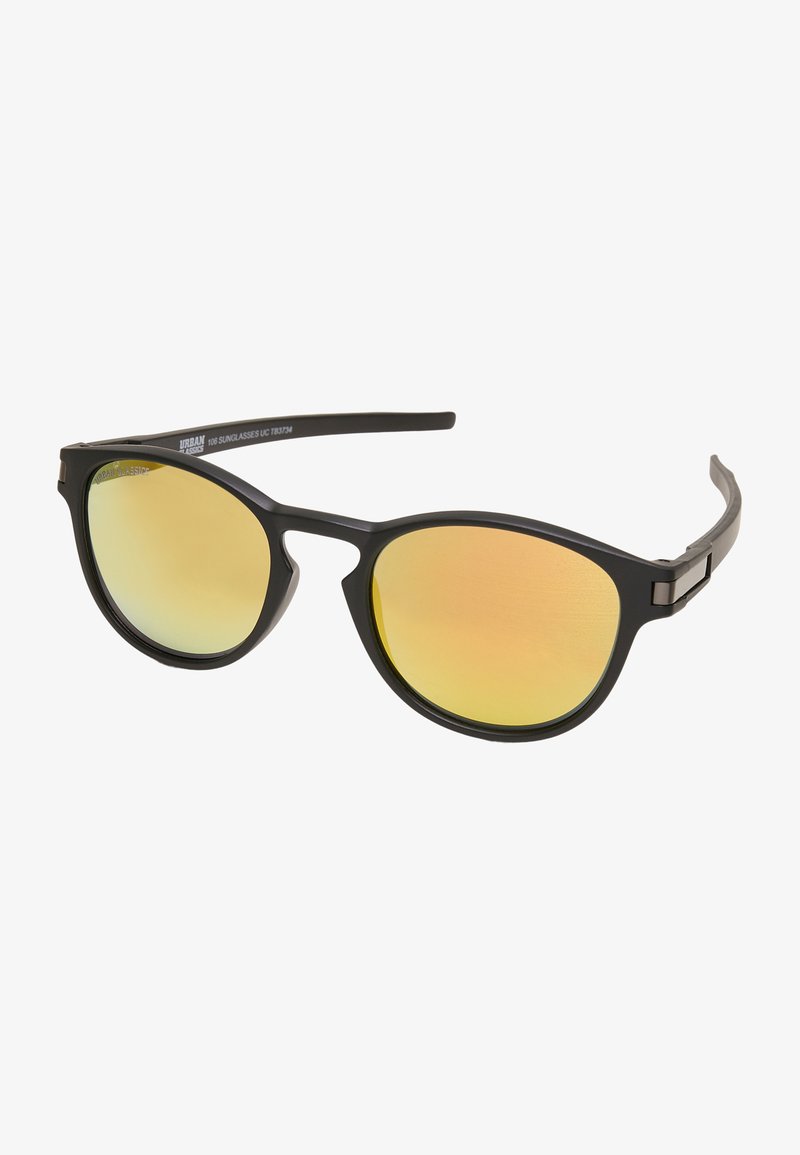 Sunglasses with a black matte frame and yellow-tinted lenses. Sleek, rounded design with a subtle logo on the arm and metal accents.