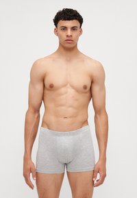 Szürke pamut boxer alsónadrág, testhezálló kialakítással. Az anyag puha textúrával rendelkezik, elől zsebbel és elasztikus derékkal.