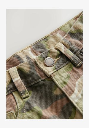 Țesătură din bumbac cu model camuflaj în nuanțe de verde, maro și bej. Este dotată cu un buton metalic cu text și detalii de cusătură în contrast.