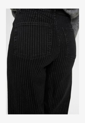 Schwarze Jeans mit Nadelstreifen, hoher Taille, zwei Gesäßtaschen und einer weichen Denim-Oberfläche. Die Streifen sind dezent und gleichmäßig verteilt.