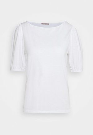 Blouse blanche à manches courtes avec manches bouffantes et poignets élastiques, avec un col rond et un tissu lisse uni.