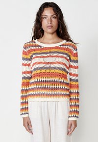 Suéter de punto multicolor con rayas horizontales en naranja, amarillo, gris y blanco, con detalles de calados y cuello redondo.