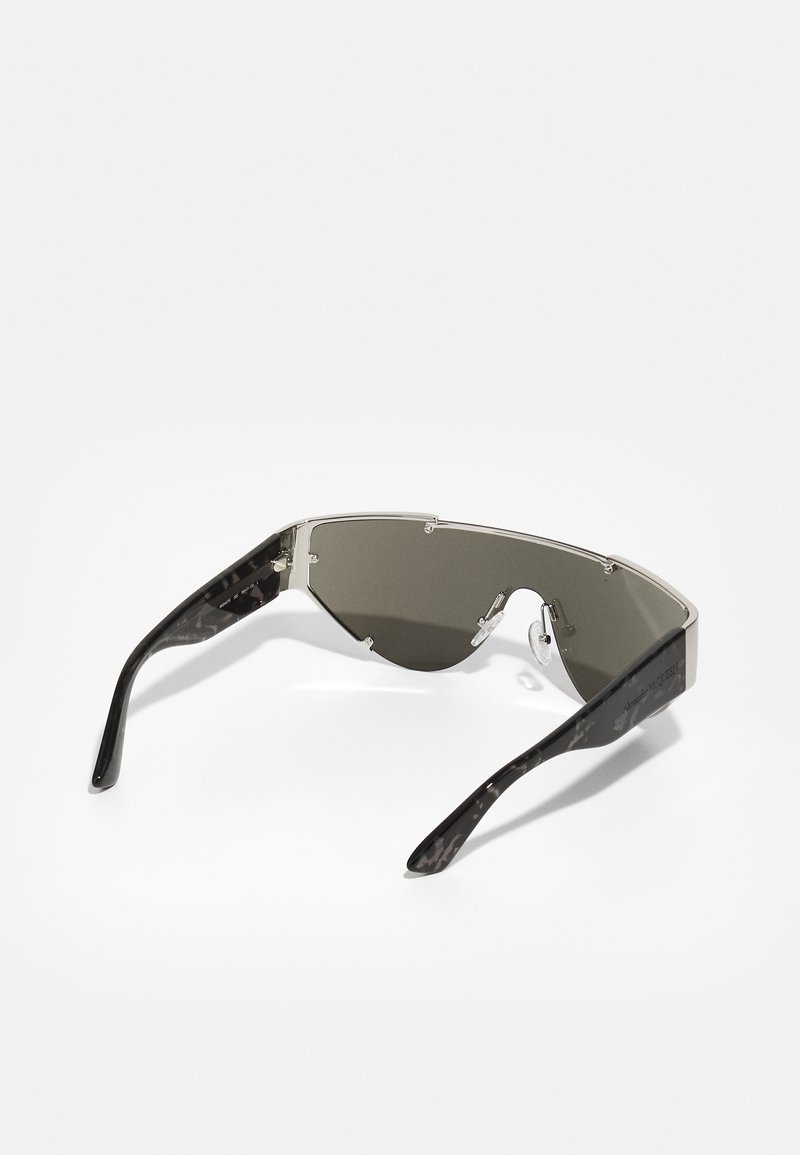 Eckige Sonnenbrille mit einem schwarz-grau marmorierten Rahmen, grauen Tönungen der Gläser, Metallakzenten und einem umschließenden Design.