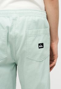 Φωτεινό πράσινο παντελόνι κορδούρι με ελαστική μέση και πίσω τσέπες, η μία τσέπη με μικρό ασπρόμαυρο σήμα Quiksilver.