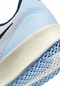 Svijetloplave atletske tenisice s teksturiranom gornjom površinom, tamnoplave naglaske i bijelu dobro podloženu obuću s uzorkom za st grip. Vidljiv Nike logo.