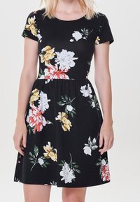 Robe noire à motifs floraux avec manches courtes, ornée de fleurs blanches, jaunes et rouges, taille cintrée et jupe évasée pour un look décontracté.