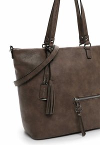 Sac fourre-tout en faux cuir marron avec des poignées doubles, une bandoulière amovible, une poche zippée à l'avant et un détail en frange.
