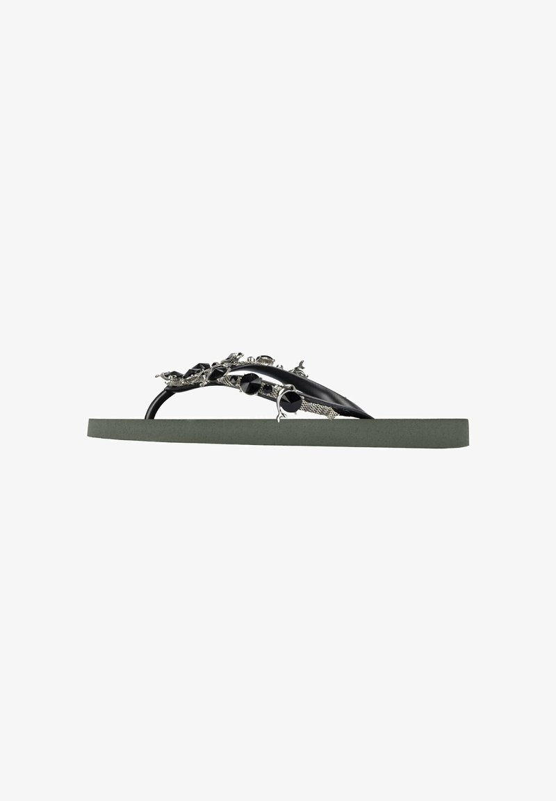 Black flip-flop sandal with decorative silver accents, featuring a textured strap and a wide, green rubber sole.