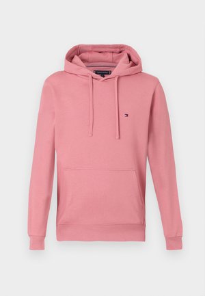 Hanorac din bumbac roz, cu glugă ajustabilă, buzunar frontal, manșete și tiv ribbate. Are un mic logo pe partea stângă a pieptului.