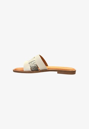 Sandale plate avec semelle cannelle et deux brides croisées en cuir blanc, dont une avec texture de cuir de serpent noir et blanc, sur fond blanc.