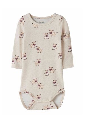 Body beige à manches longues pour bébé avec fermeture à pression et imprimé de vaches marron et blanches style dessin animé sur l'ensemble.
