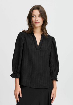 Blusa nera a righe con scollatura a V, accentuata da maniche arricciate e un tessuto texturizzato. Design semplice e vestibilità regolare.