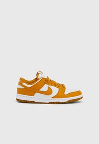 Tenisky Nike Dunk Low s kombinací oranžové a bílé kůže, s texturovaným vzorem a bílou gumovou podrážkou. Jemné značení na patě.
