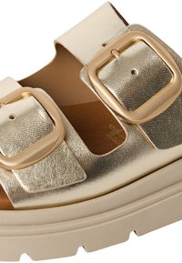 Sandal con piattaforma metallica dorata, dotata di due ampie cinghie e grandi fibbie quadrate. Superficie testurizzata con interno liscio.