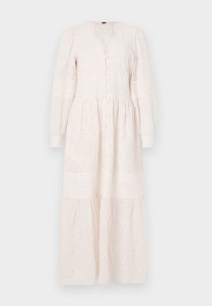 Robe blanche à manches longues avec boutons sur le devant, tissu texturé avec des motifs brodés, et une jupe à volants.