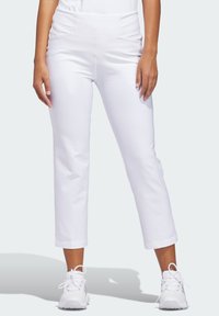 Λευκά παντελόνια capri με λεία υφή, ψηλή μέση και πλαϊνές τσέπες. Φορεμένα με λευκά αθλητικά παπούτσια, με casual εφαρμογή.