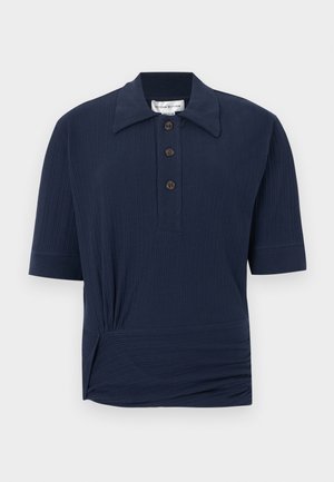 Tamsiai mėlynas trumpomis rankovėmis polo marškinėliai su ribine tekstūra, trimis rudos spalvos mygtukais ir susmulkintu dizainu liemens linijoje.