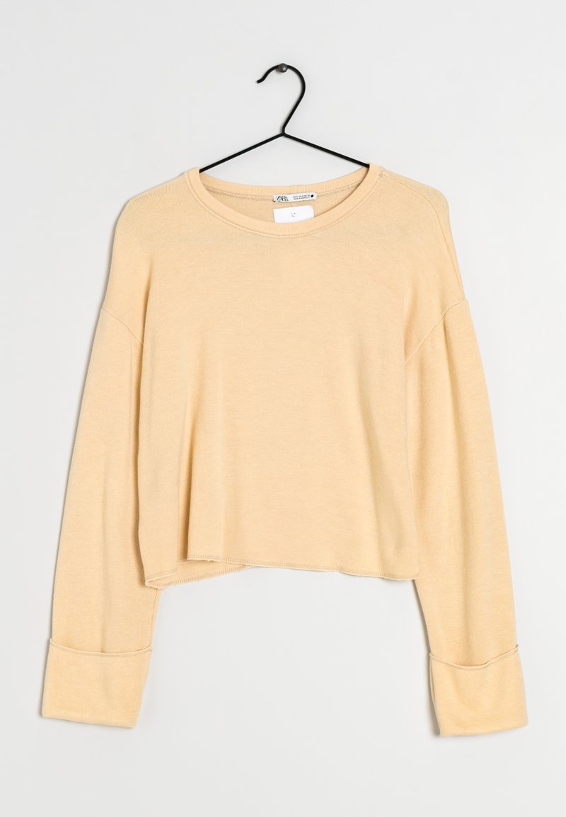 Hellgelbes, kurzes Sweatshirt mit langen, lockeren Ärmeln, rundem Halsausschnitt und gerippten Bündchen. Weicher, strukturierter Stoff und unvollendete Saumdetails.