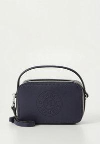 Navy leather crossbody bag with a zip closure, embossed logo, and adjustable strap. Rectangular shape with smooth texture and minimalist design.