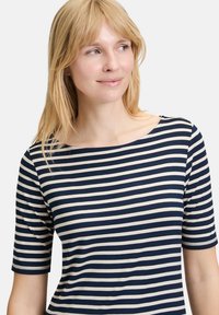 Granatowo-kremowy, w poziome paski, krótki rękaw top z okrągłym dekoltem, wykonany z miękkiego materiału. Paski są równomiernie rozmieszczone i poziome.