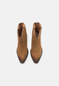 Brązowe zamszowe botki za kostkę z wydłużonym noskiem i dekoracyjnym przeszyciem. Posiadają boczne otwory i gładką fakturę.