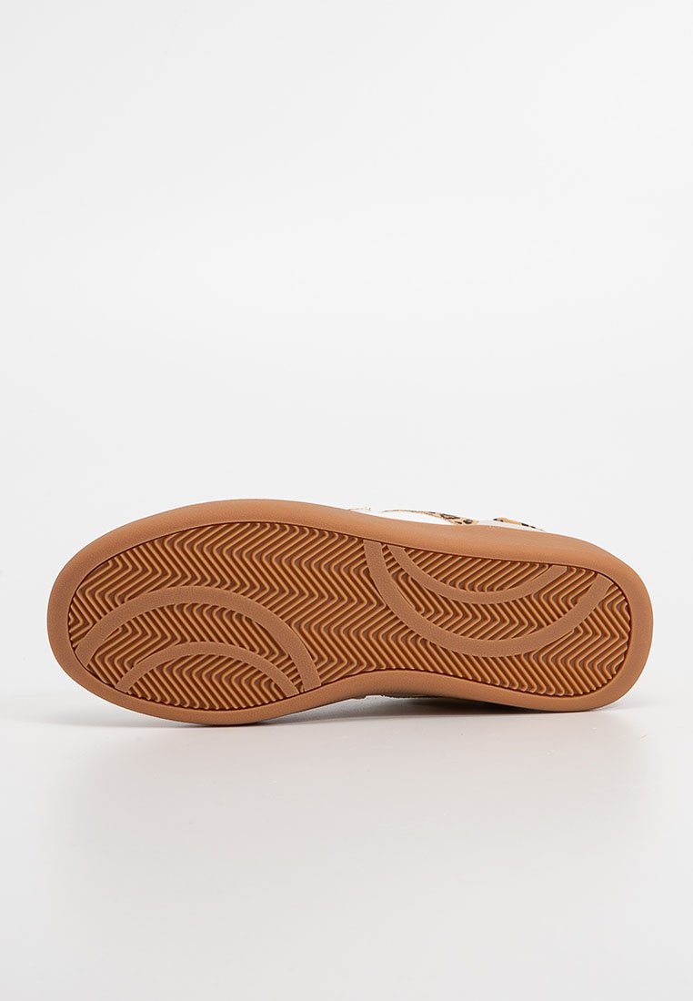 Suela de zapatilla con material de goma, que presenta un patrón de espiga y curvas suaves, diseñado para ofrecer tracción y durabilidad.