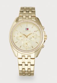 Orologio da polso Tommy Hilfiger in tonalità oro con quadrante in cristallo, tre sottodial per giorno, data e ora in formato 24 ore, e bracciale metallico a maglie.