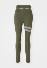 Leggings vert olive avec une taille haute affichant le logo "STRONGER" en blanc, et deux bandes réfléchissantes horizontales sur la jambe gauche.