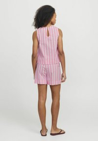 Rožinė dryžuota be rankovių palaidinė su skylute nugaroje, derinama su atitinkamais šortais. Lengvas audinys. Kasdieniškas dizainas, tinkantis šiltam orui.