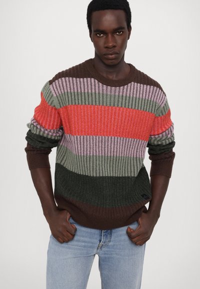 Knitted sweater with horizontal stripes in red, pink, green, and brown. Features a ribbed texture and a round neckline.