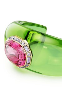 Genomskinlig grön resinarmband med en stor, rosa oktagonal ädelsten, omgiven av mindre, klara rektangulära stenar och gulddetaljer.