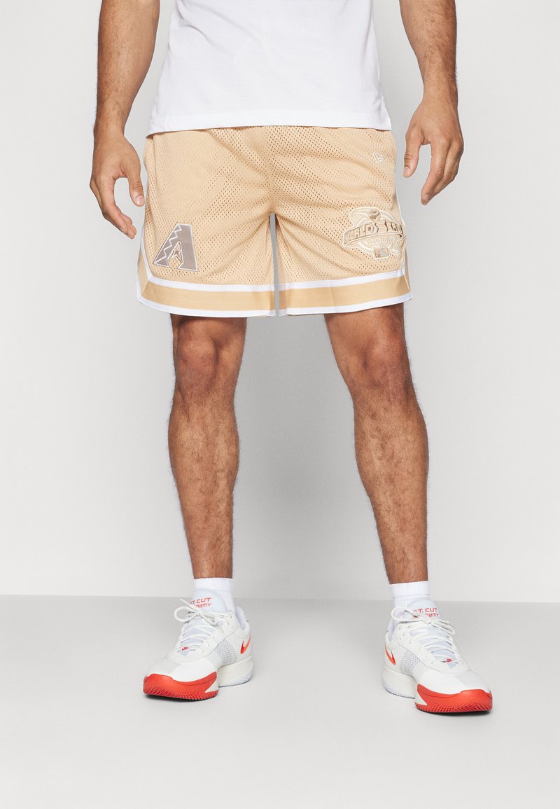 Helle beige Mesh-Shorts mit weißen Akzenten, mit einem gestickten Logo am linken Bein und einem Grafikdruck auf der rechten Seite.