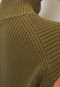 Olivengrøn, struktureret strikket ærmeløs top med høj krave og detaljeret ribmønster langs sømmene, der viser et struktureret design.